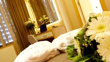 Relax in a serene space with a comfortable bed, bedside table, and elegant decor.