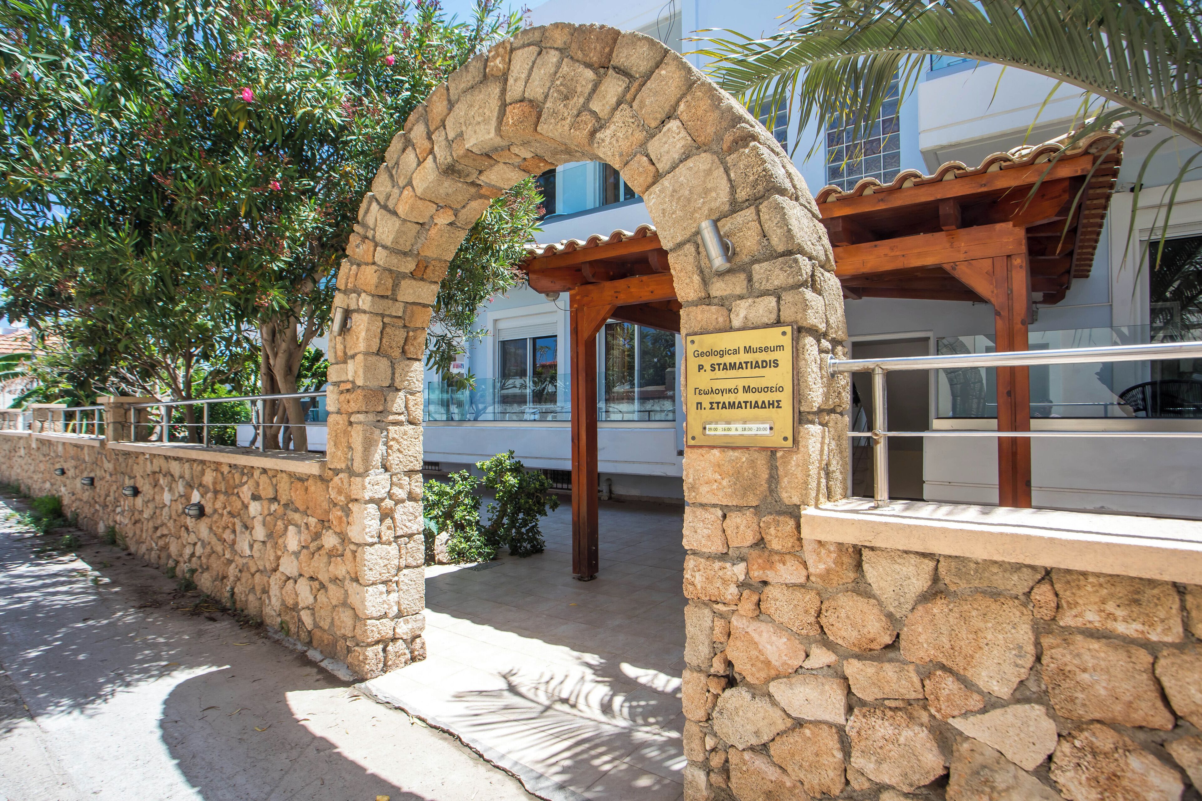 A stone archway leading to a building with a sign for the Geological Museum.