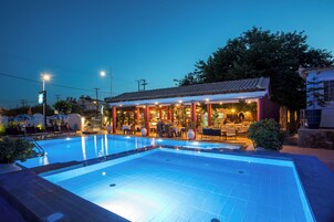 Una piscina al aire libre, sombrillas, sillones reclinables de piscina