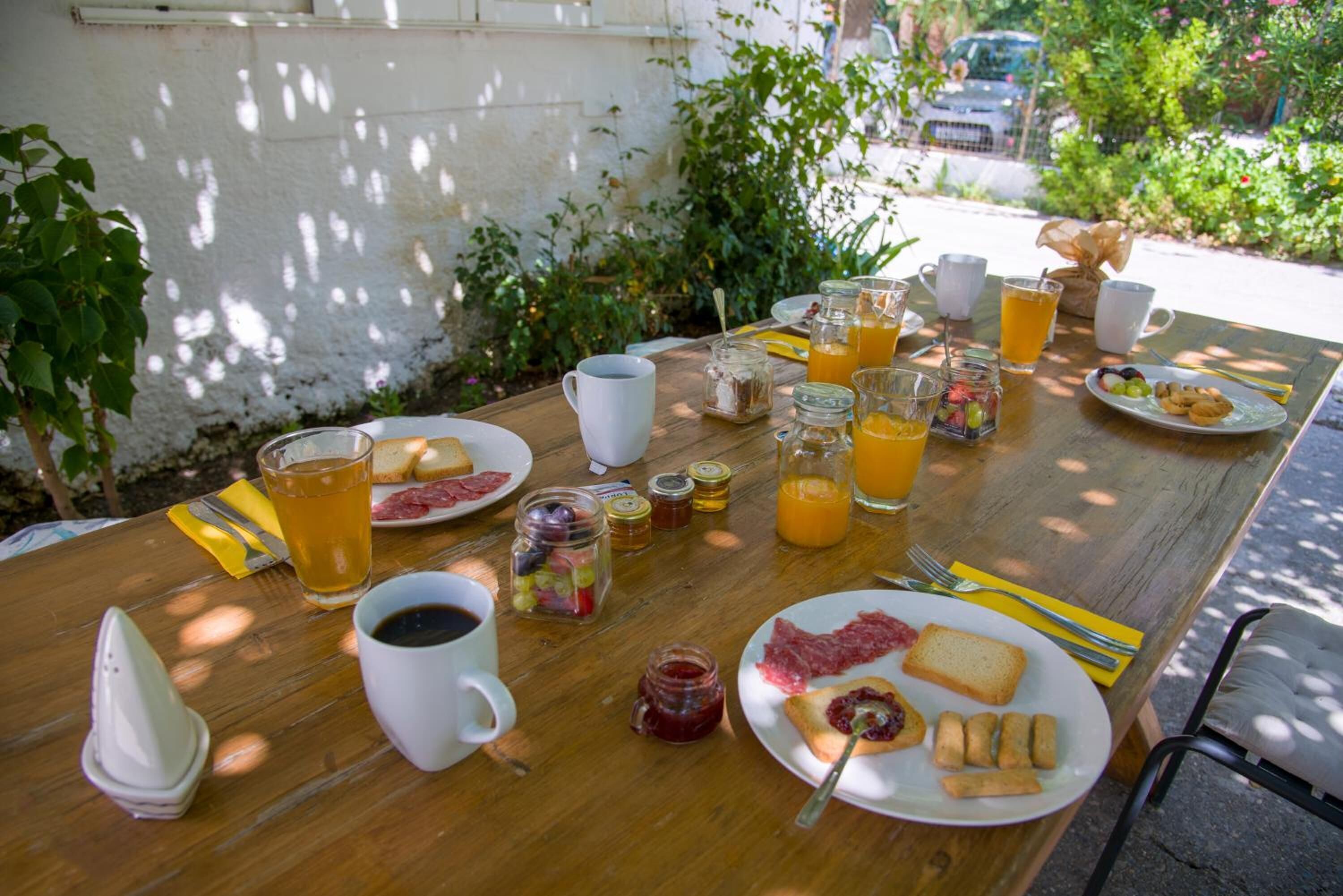 A breakfast table with various food items and drinks.