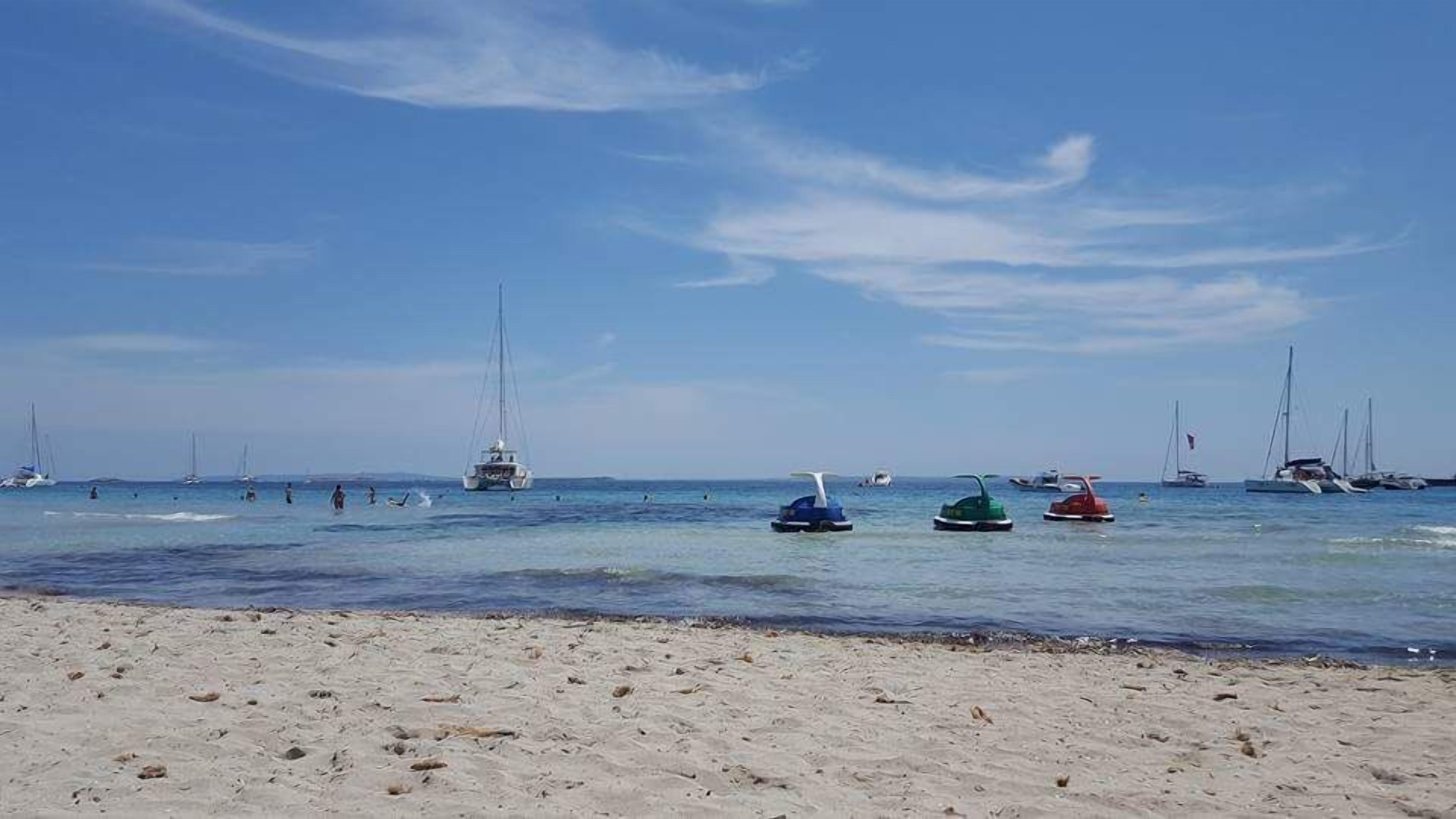 Une plage avec des bateaux et une eau calme.