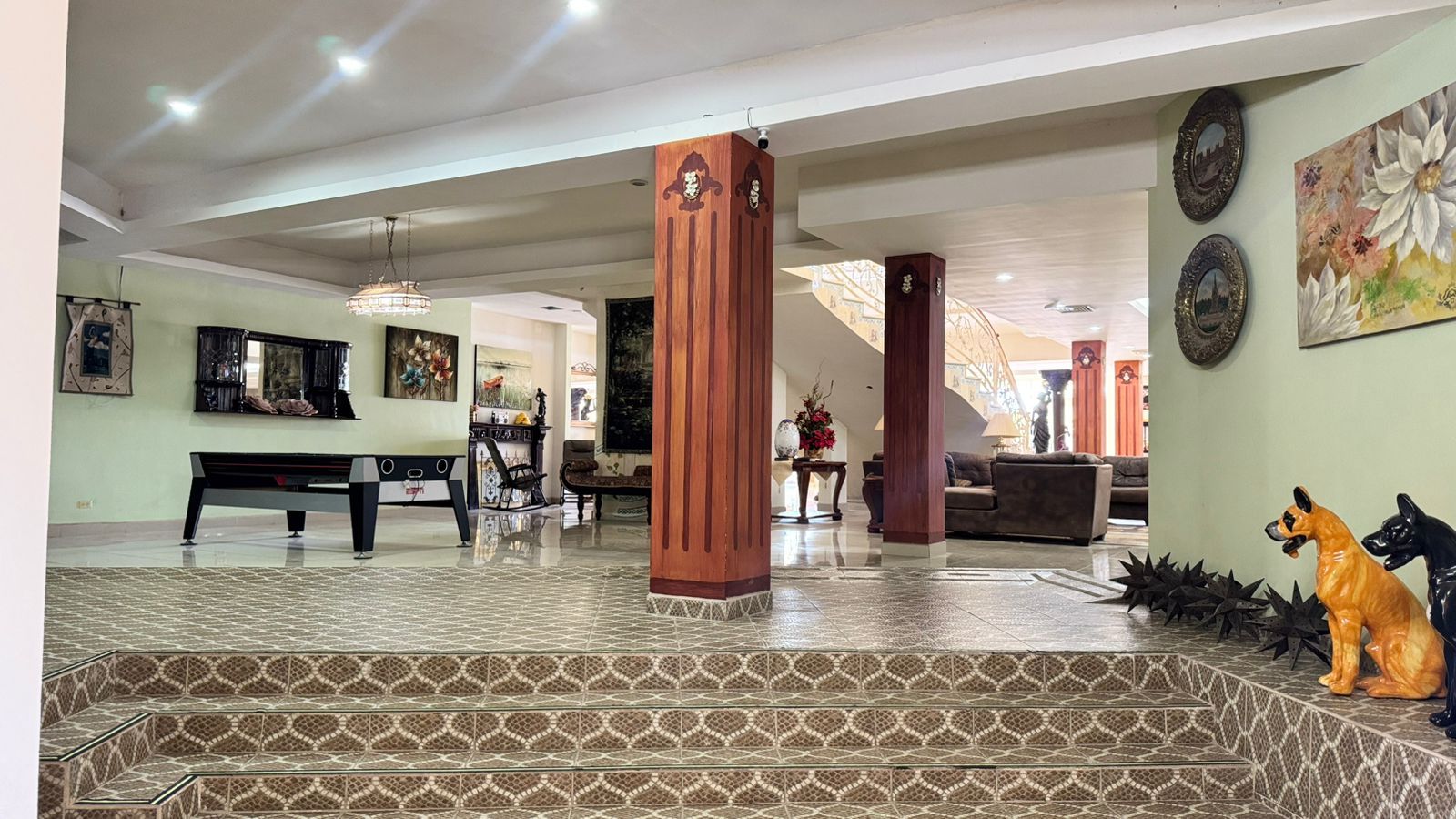 A spacious lobby with a grand staircase, a piano, and a seating area.