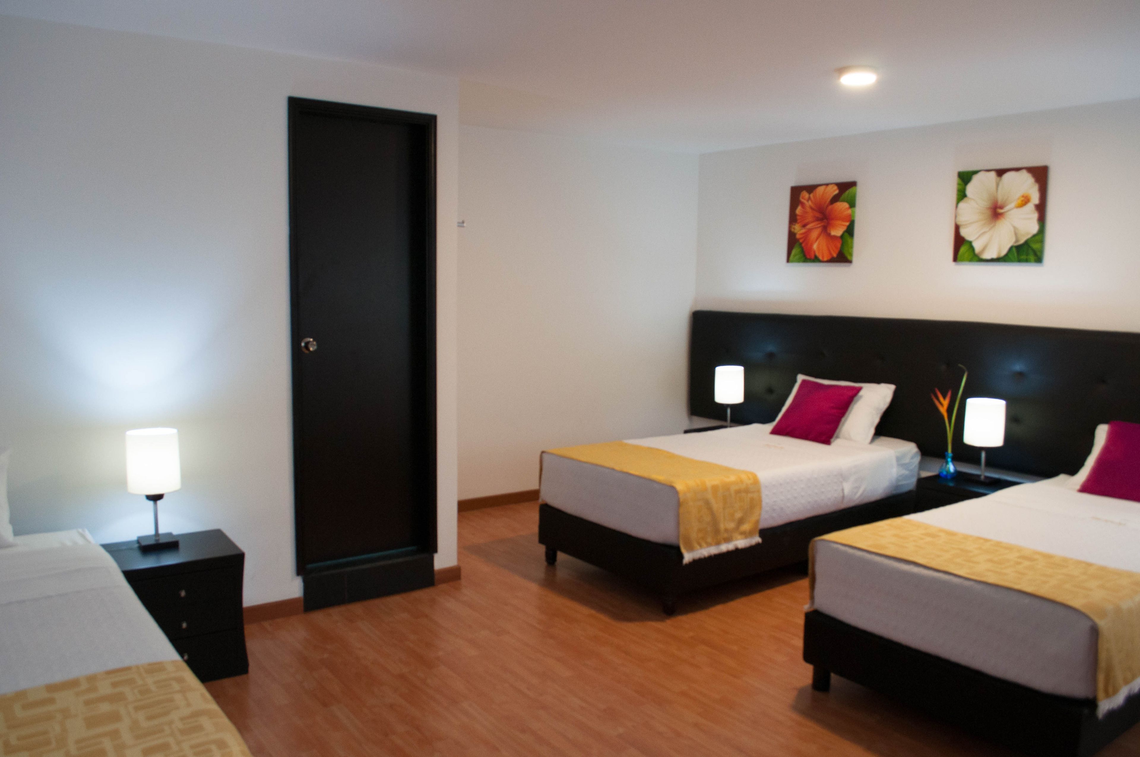 A hotel room with two beds, a wardrobe, and a television.