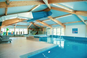 Una piscina techada, sillones reclinables de piscina