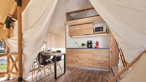 Una cocina compacta con armarios de madera, un microondas y una cafetera.