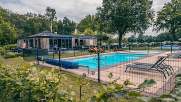 Una piscina al aire libre, sillones reclinables de piscina