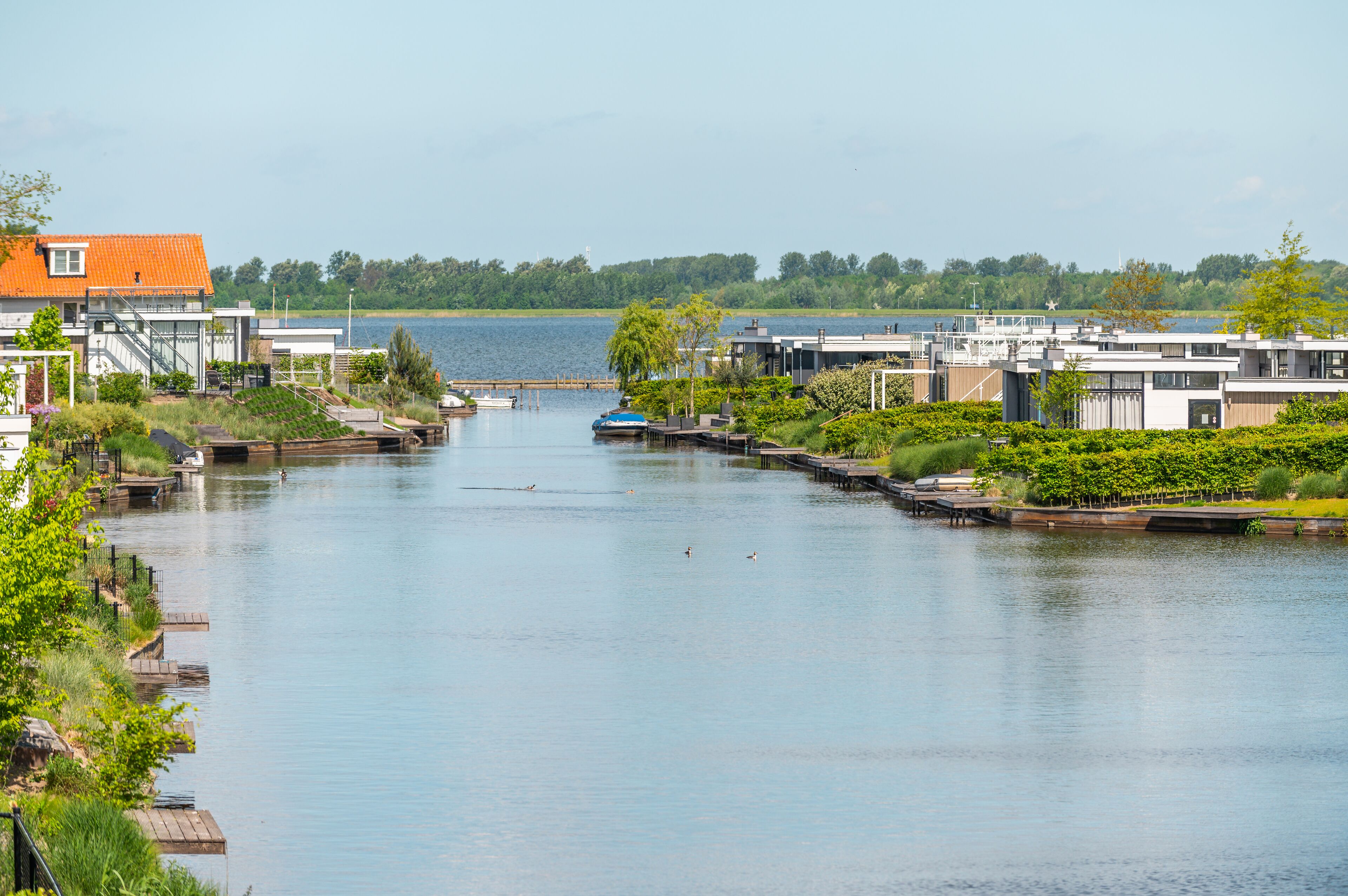Una propiedad a orillas del río con arquitectura moderna, un muelle y vistas al agua.