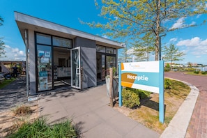 A modern building with a reception area, glass doors, and a sign indicating it's a reception. - EuroParcs Veluwemeer (Nunspeet)