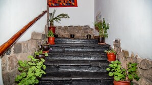 A staircase with stone steps and potted plants on either side. - Kori Gems Inn (Cusco)