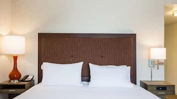 Habitación de hotel con una cama grande, dos mesitas de noche, un teléfono y una lámpara a cada lado.
