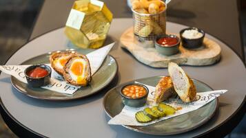 A table with plates of food, including sandwiches and sides.