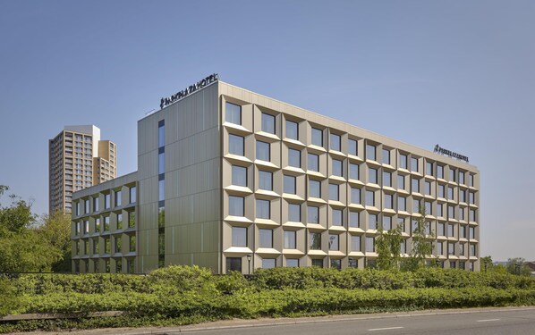 Ein modernes Hotelgebäude mit einem Raster aus Fenstern und einer flachen Dachfläche.