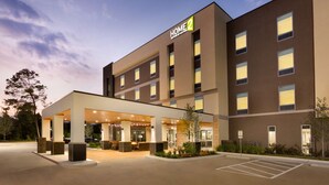 Un hôtel moderne doté d’un espace extérieur couvert avec des sièges et de nombreuses fenêtres.
