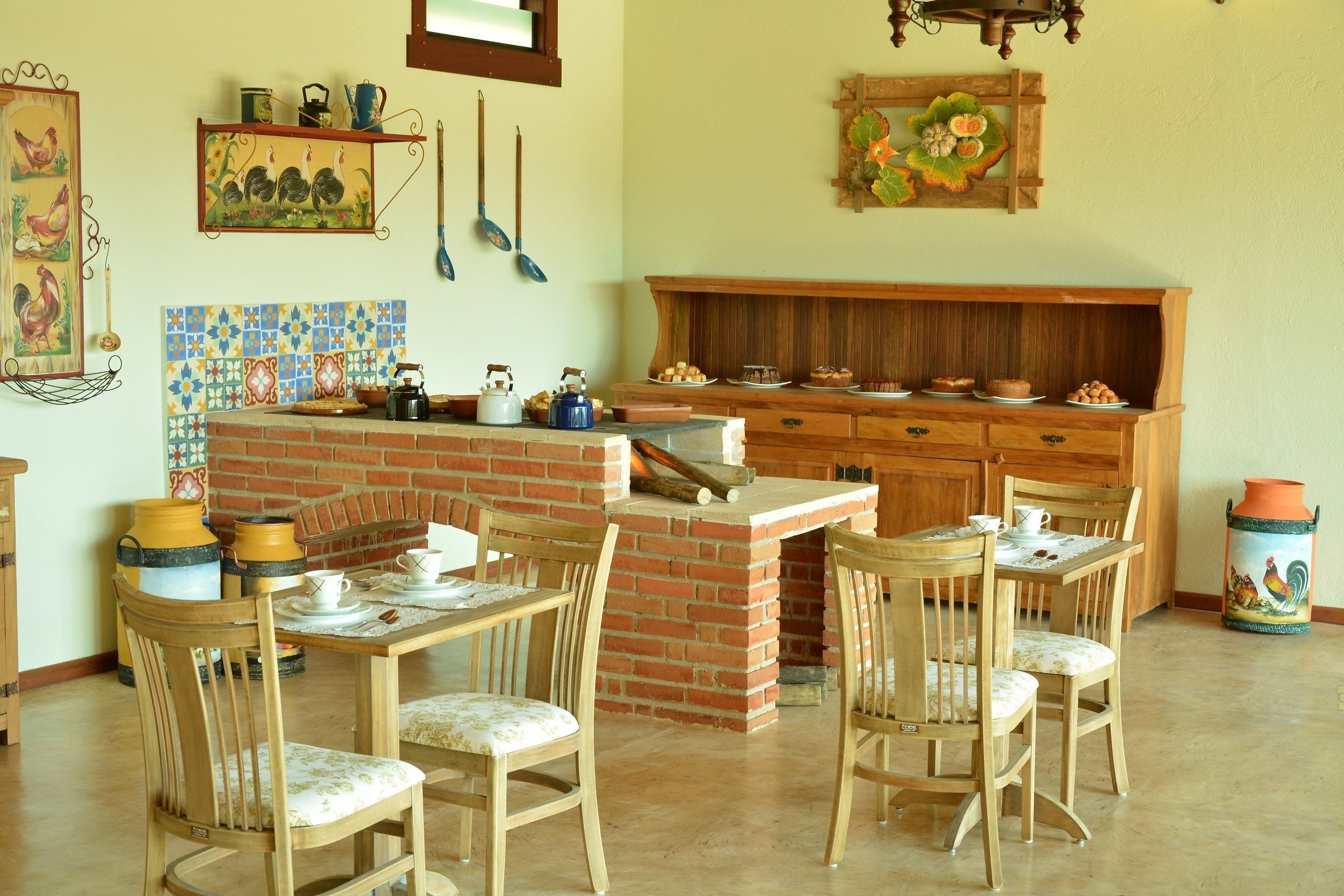 A kitchen with a brick island, wooden chairs, and a dining table.