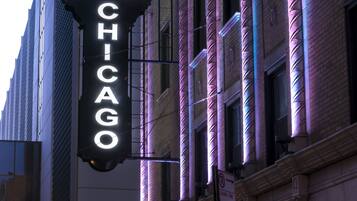 Ein leuchtendes Neon-Schild eines Hotels mit dem Schriftzug "HOTEL CHICAGO" in weißen Lettern vor schwarzem Hintergrund.