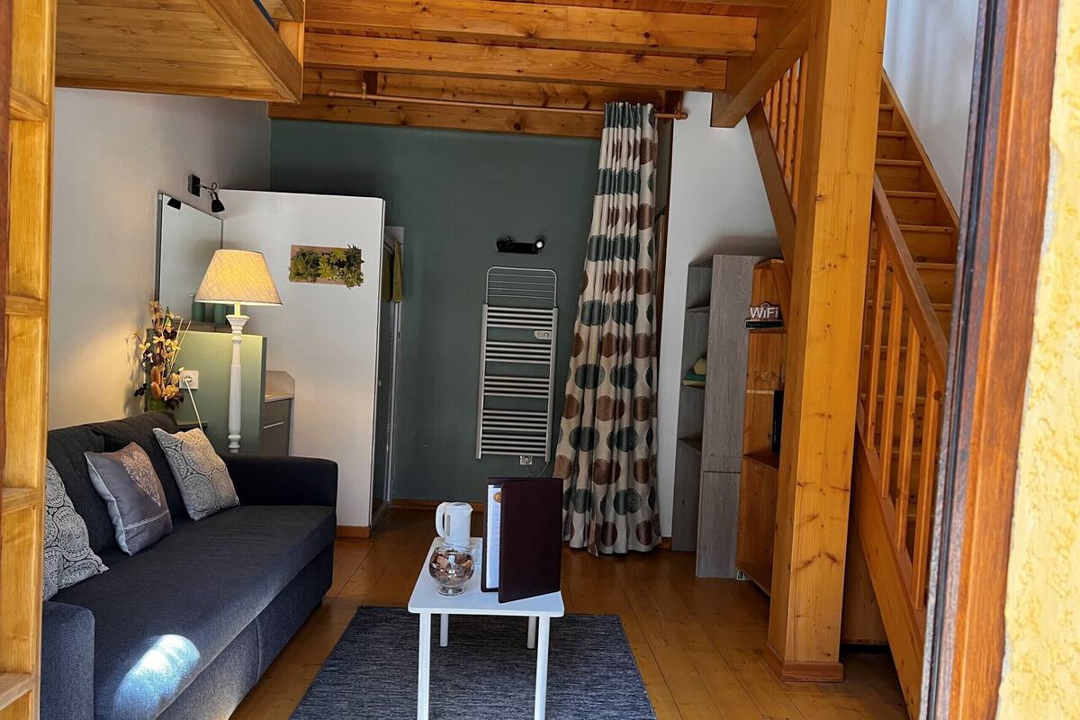 Una sala de estar acogedora con un sofá, una mesita, una lámpara y un radiador.