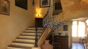 A staircase with a wrought iron railing, a vase, and a lamp on the landing. - Mas Petit Fourchon (Arles)