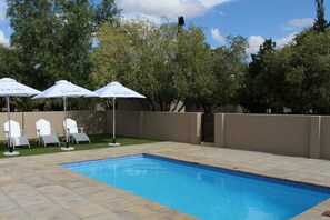 Una piscina al aire libre, tumbonas
