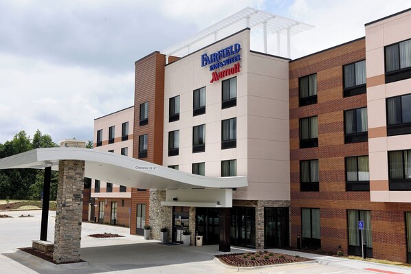 Un hotel Fairfield Inn & Suites by Marriott con un diseño moderno, que presenta fachada de ladrillo, múltiples ventanas y una zona de entrada cubierta.
