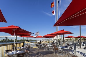 Enjoy al fresco dining with a view of the water and a picturesque bridge in the background.