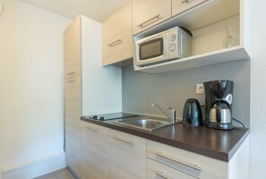 A compact kitchen with a microwave, coffee maker, and a sink. - Résidence Odalys Pra Sainte Marie (Vars)