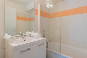 A bathroom with a white sink, mirror, and a glass shower enclosure. - Résidence Odalys Pra Sainte Marie (Vars)
