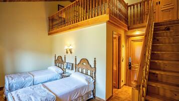 Quarto com duas camas, escada de madeira e varanda.