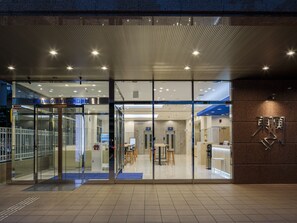 A modern hotel entrance with glass doors, a reception desk, and a seating area visible inside. - Toyoko Inn Nagoya-eki Sakuradori Shinkan (Nagoya)