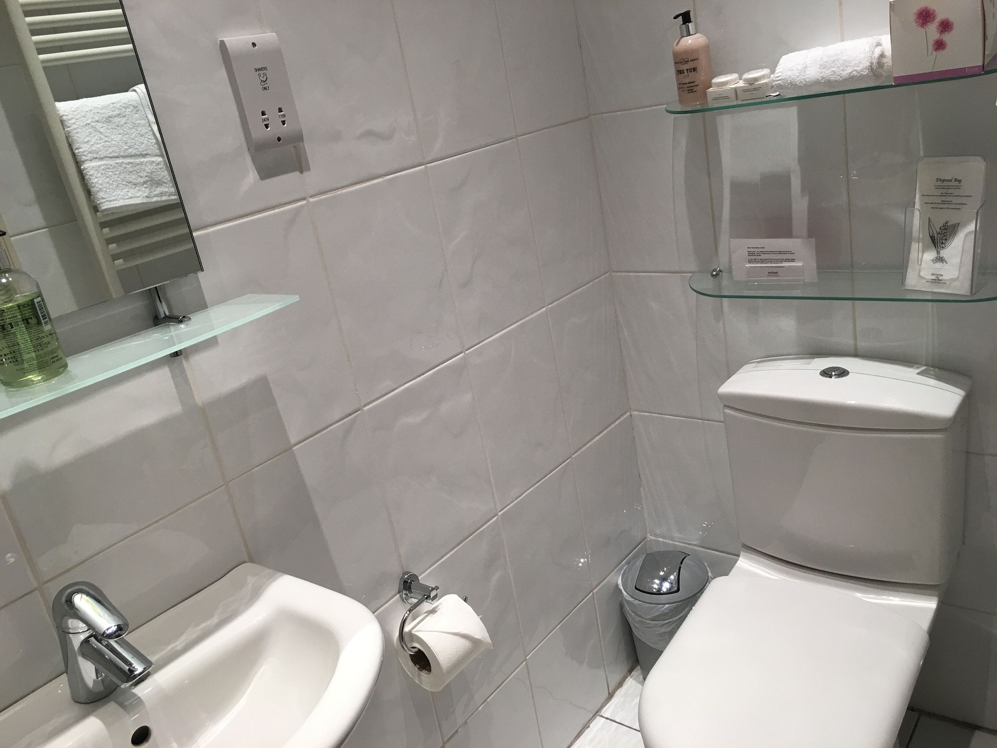 Een moderne badkamer met een hygiëneslot, toilet en wastafel.