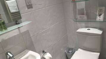 Een moderne badkamer met een hygiëneslot, toilet en wastafel.