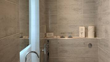 A modern bathroom with a sink, toilet, and shower area.