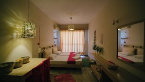 A bedroom with a bed, bedside table, lamp, and a mirror. - Gorgona Studios (Rhodes)