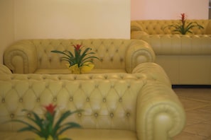 A yellow tufted sofa with a small plant on it. - Hotel Piccolo Paradiso (Toscolano Maderno)