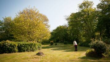 Golfers can enjoy a serene round on the well-maintained fairway surrounded by lush greenery and trees.