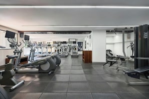 Academia com esteiras, elípticos e equipamentos de musculação.