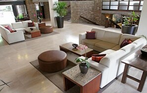 Ein geräumiger Wohnbereich mit einem weißen Sofa, einem Couchtisch und einem Kamin.