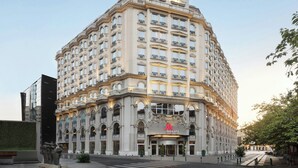 Ein großes, historisches Hotel mit klassischer Architektur, das mehrere Balkone und einen markanten Eingang aufweist.