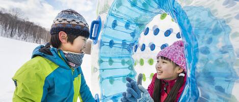 Two children interacting with a transparent ice sculpture.