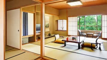 A traditional Japanese room with tatami flooring, a low table with cushions, and sliding doors.
