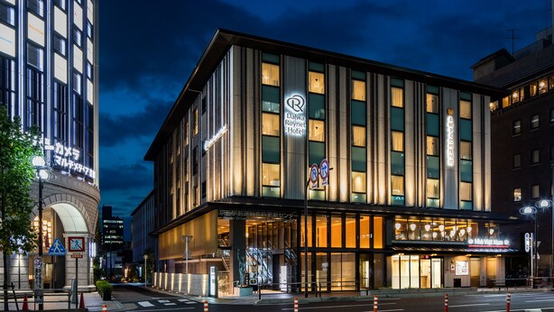 A modern hotel with a prominent 'R' logo, large windows, and a well-lit entrance. - Daiwa Roynet Hotel Kyoto Ekimae PREMIER (Kyoto)