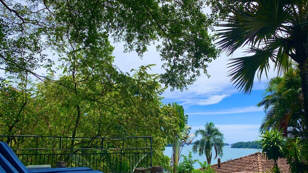 Zona de piscina con sillones de descanso y vista a un cuerpo de agua.