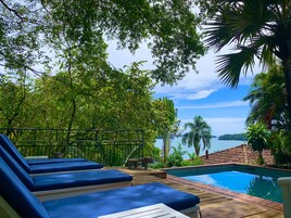 Una piscina al aire libre, tumbonas