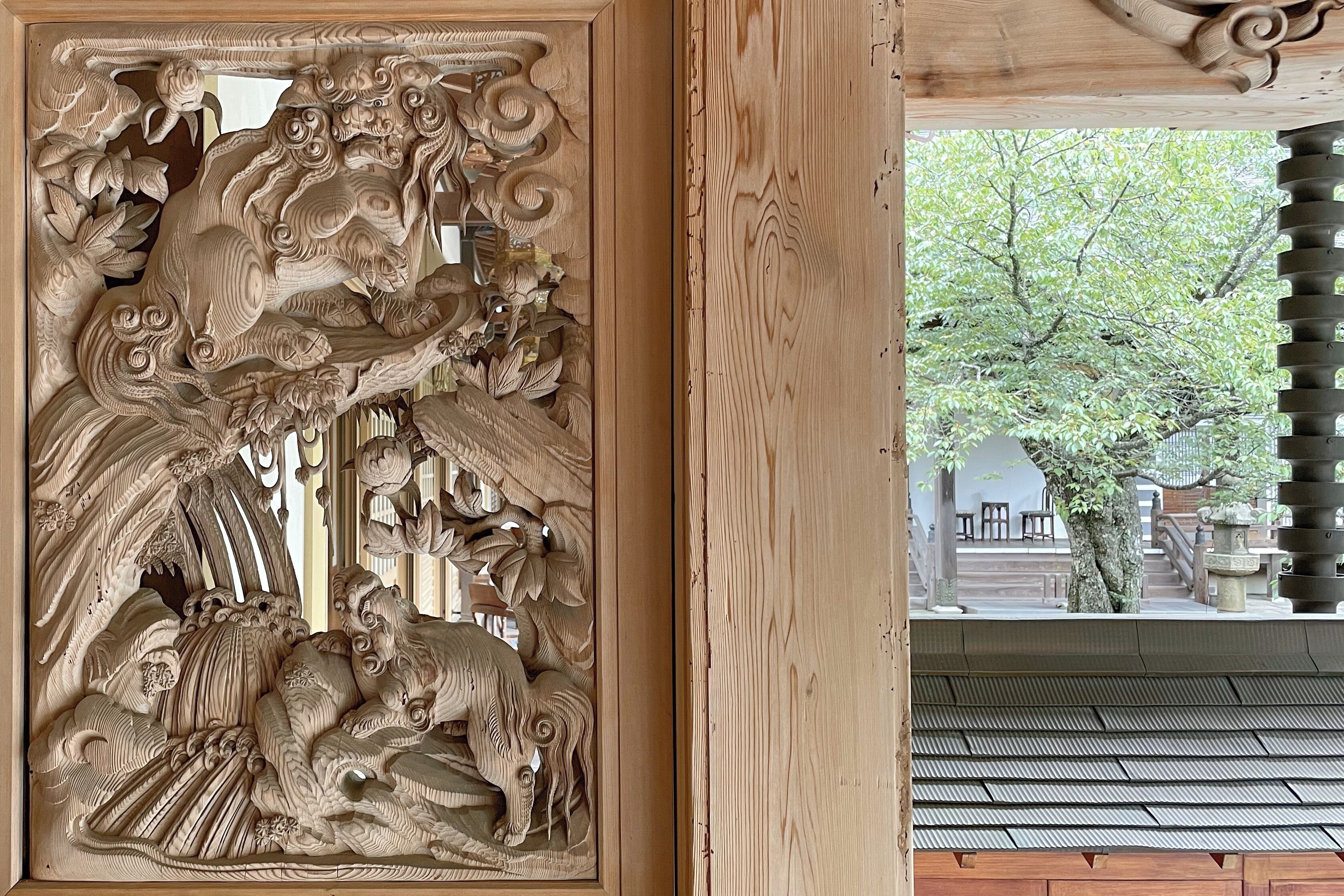A detailed carved wooden panel with a traditional design, likely part of a building's interior architecture.