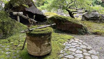 A garden with moss-covered rocks, a stone pathway, and wooden structures.