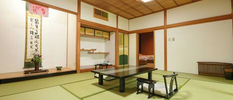 Ein traditioneller japanischer Raum mit Tatami-Boden, einem niedrigen Tisch, einer Bank und einer Schiebetür.
