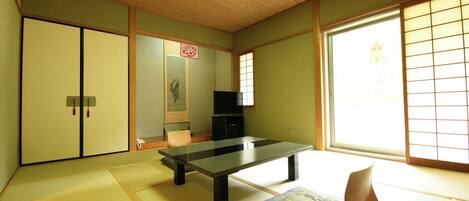 Um quarto japonês tradicional com tatames, uma mesa baixa, portas deslizantes e uma grande janela com biombos shoji.