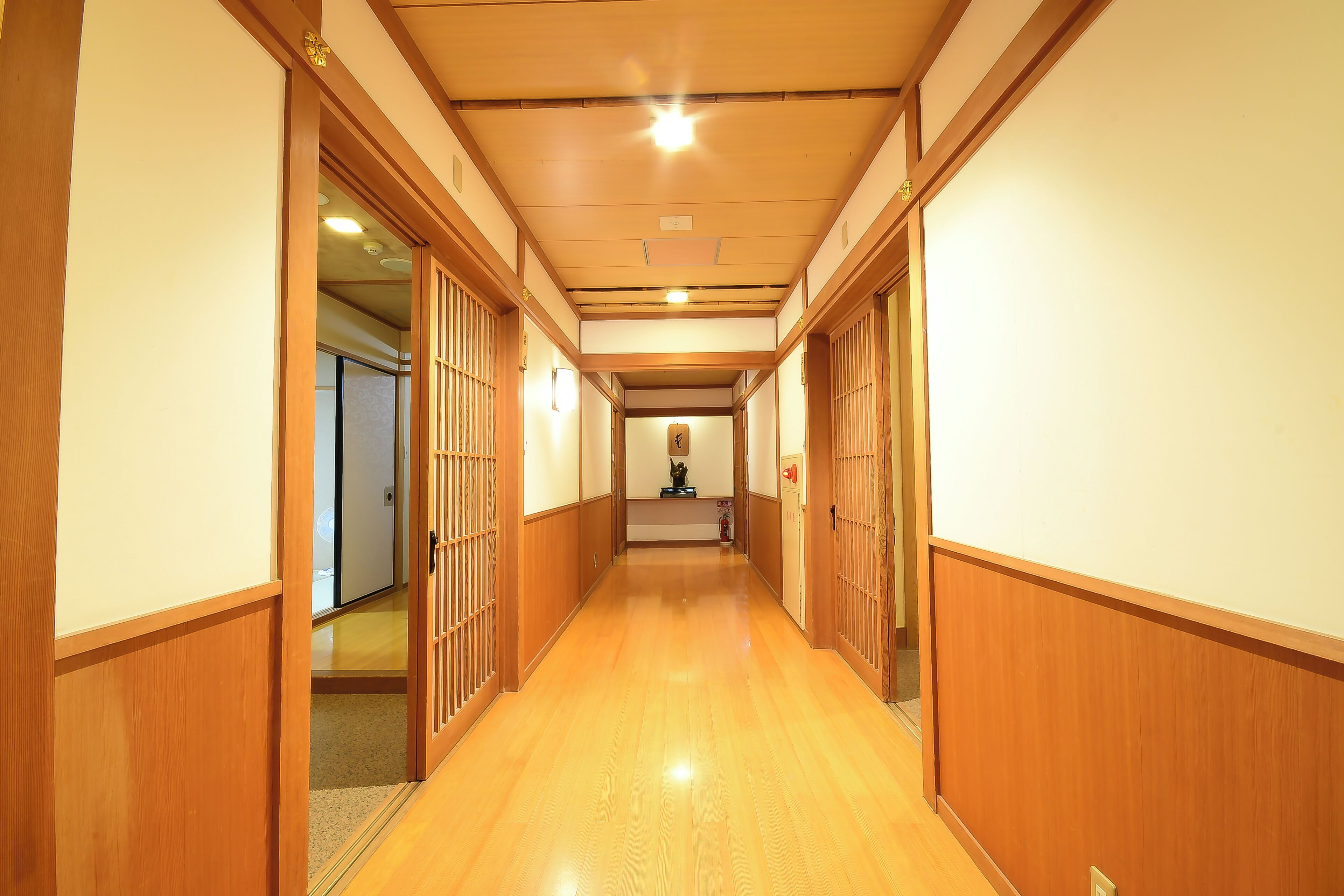 Un couloir doté d’un plancher en bois et de portes coulissantes traditionnelles.