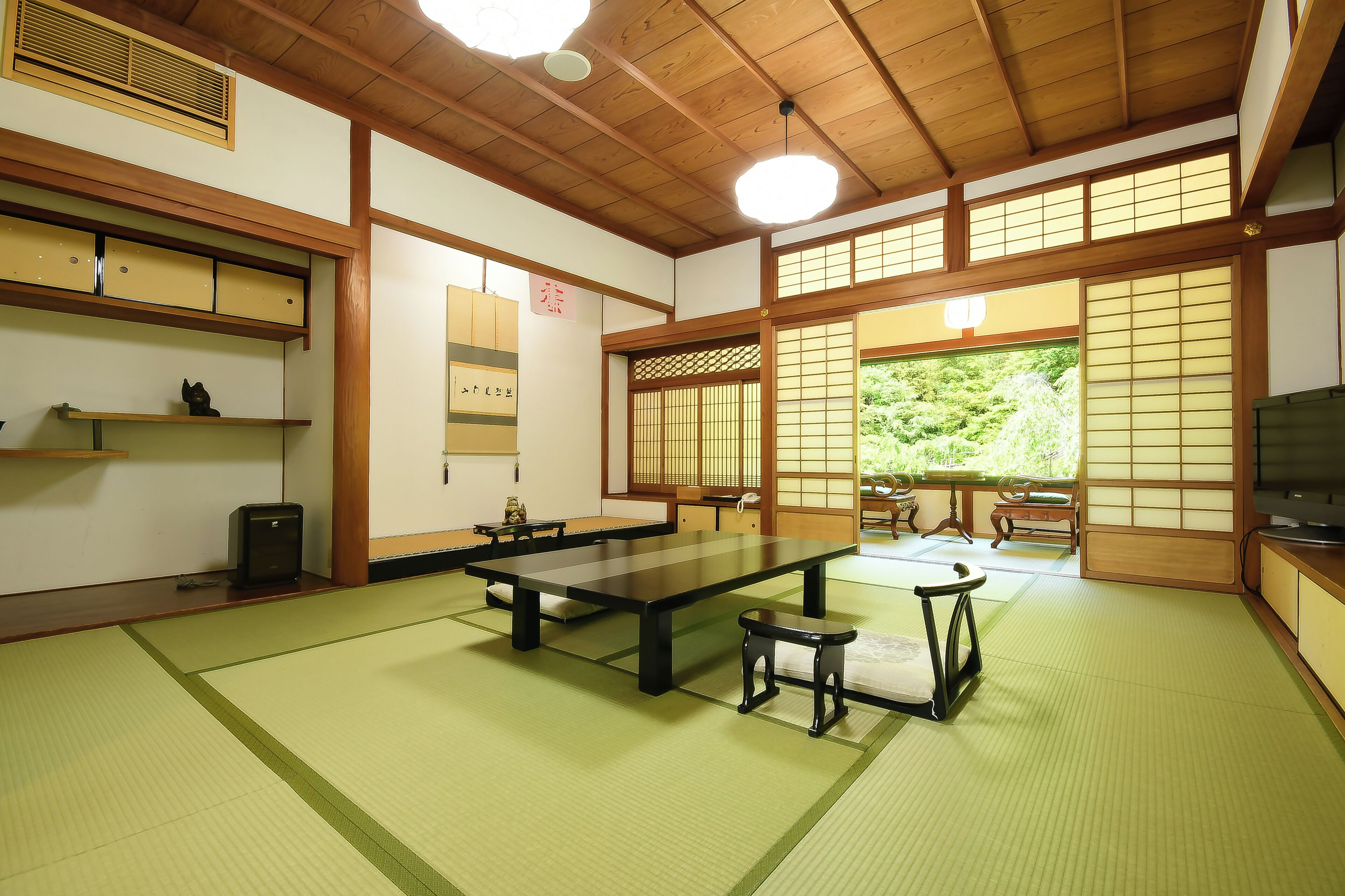 A traditional Japanese room with tatami flooring, a low table, and sliding doors.