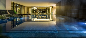 A modern indoor swimming pool with clear glass walls, a clean, reflective floor, and a well-lit interior. - Hyde Park Chiangmai (Chiang Mai)