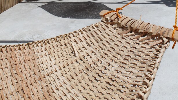 A hammock suspended between bamboo poles in an outdoor area with a concrete floor and a wooden fence. - Roger's Place Gay Guesthouse - Caters to Gay Men (Boracay Island)
